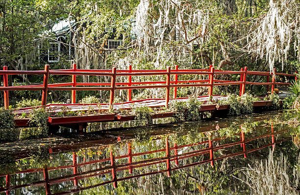 istock Old iron red bridge crosses swamp waters. 637622860