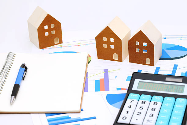 istock Miniature model of house and chart printed documents 637622910