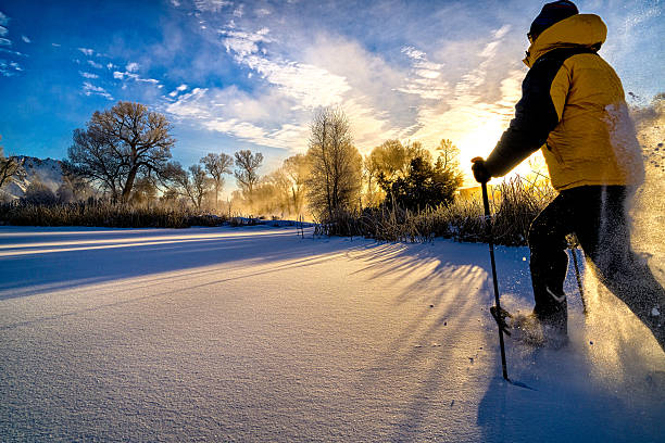 schneeschuhwandern bei sonnenuntergang - recreate stock-fotos und bilder