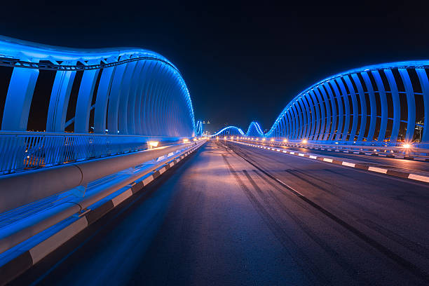 мост мейдан ночью с красивыми синими огнями - middle east highway street night стоковые фото и изображения