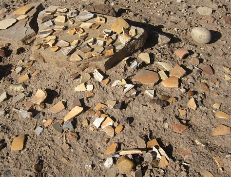 An artifact scatter with pottery fragments and a couple of stone tools.  The artifacts were observed in the high desert of the American Southwest.