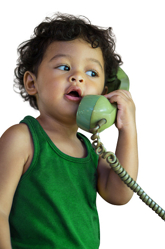 Little asian baby boy talking on a green retro telephone isolated on white background.