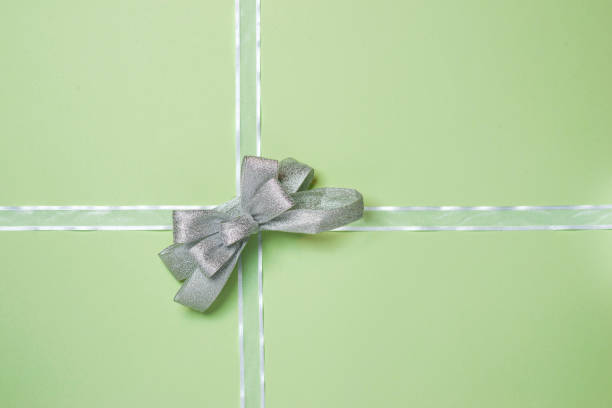 Two gifts wrapped in (different) shiny metalic green paper with green bows.  The smaller gift also has a silver strap. Ideal Christmas Present type Photo.Other