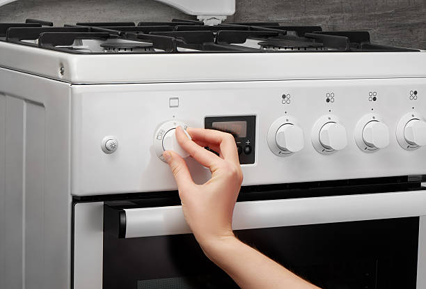 istock Female hand turning on white kitchen gas stove on gray 637639178