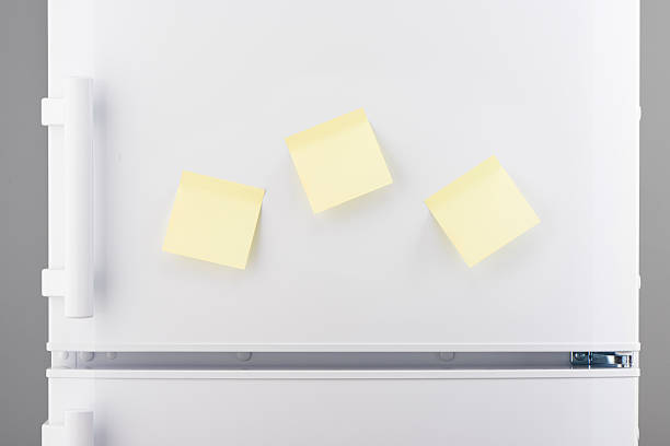 istock Three blank yellow sticky paper notes on white refrigerator 637639628