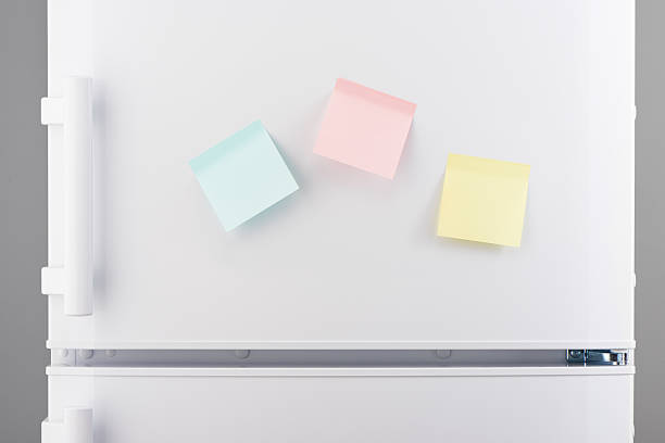 istock Yellow, pink and blue sticky paper notes on white refrigerator 637639692
