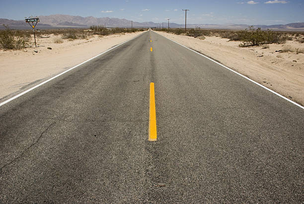 istock Long straight road through desert landscape, California 637642486