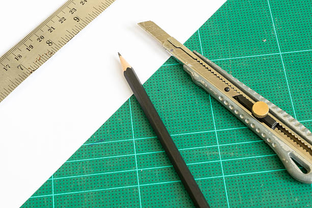 istock cutter and pencil with ruler on green cutting mat 637644220