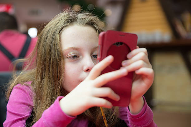 istock LIttle girl with cellphone 637646632