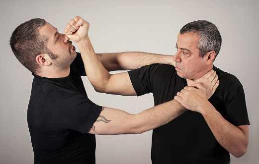 Kapap instructor demonstrates street fighting self defense technique against holds and grabs with his student