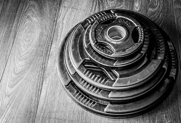 Weights. Weight plates on the gym floor. Black and white.