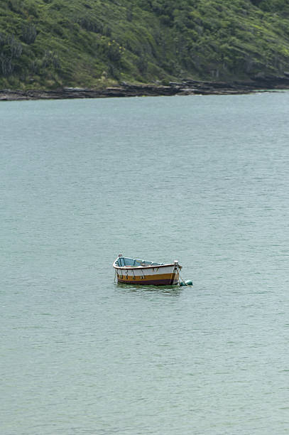istock Small boat anchored near shore on calm sea 637660394