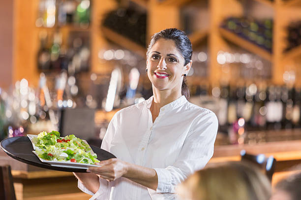 Waitress in restaurant serving food to customers