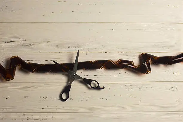 Top view of scissors cutting film strip