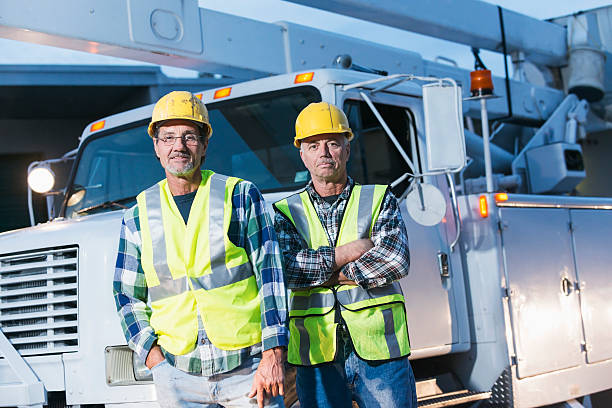 istock Two workmen in safety vests with truck 637673866