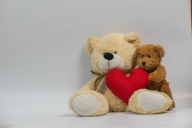istock Teddy bear holding heart shape pillow on with background 637681358