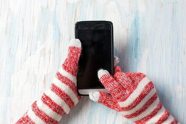 hands using phone in winter gloves - glove winter wool touching imagens e fotografias de stock
