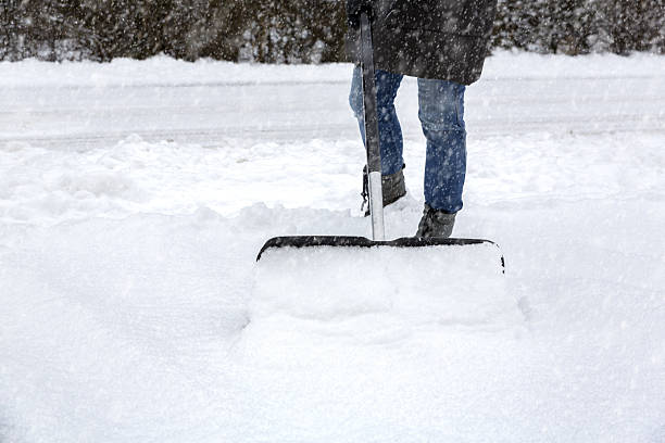istock Woman shoveling snow on pavement 637685520
