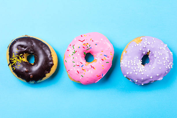 istock Colorful round donuts on blue background. Flat lay, top view. 637688844