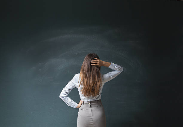 femme d’affaires regardant le tableau noir vide - professor teacher female blackboard photos et images de collection