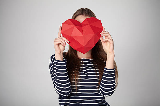 istock Woman holding red polygonal paper heart shape 637689812
