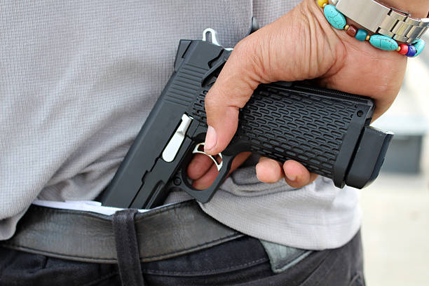 istock gangster concealing his gun behind his back 637690986