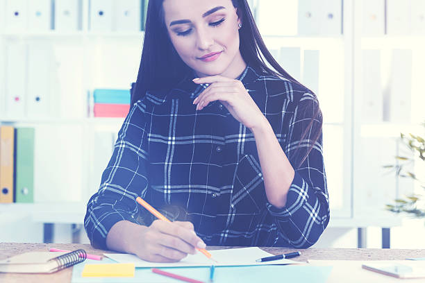istock Serious woman drawing with pencils 637692128