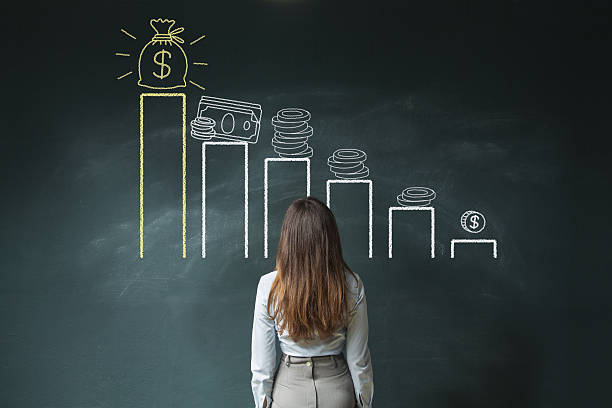 Financial chart on chalkboard Business woman standing in front of a blackboard with a financial chart salary stock pictures, royalty-free photos & images