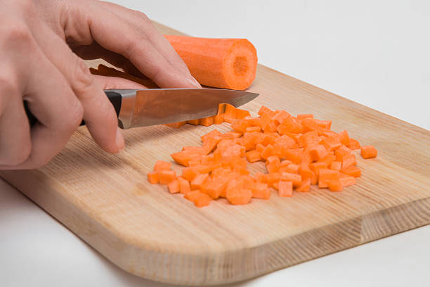 istock Woman's hand with a knife cuts the carrot.  Healthy eating. 637697130