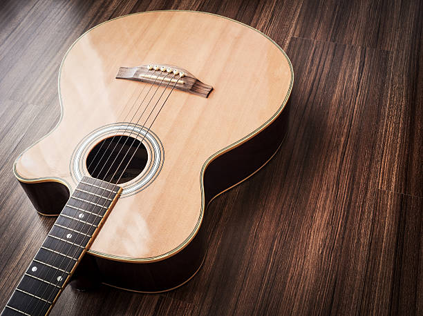 istock Vintage acoustic guitar in close range on wood background. 637699554