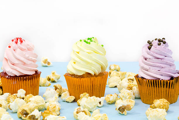 istock Pink frosted cupcakes on light blue background 637704752