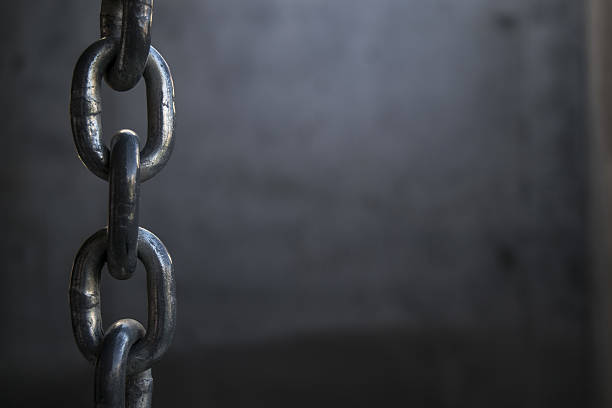 Hanging Chain Chain Hanging Near A Concrete Wall anchor chain stock pictures, royalty-free photos & images