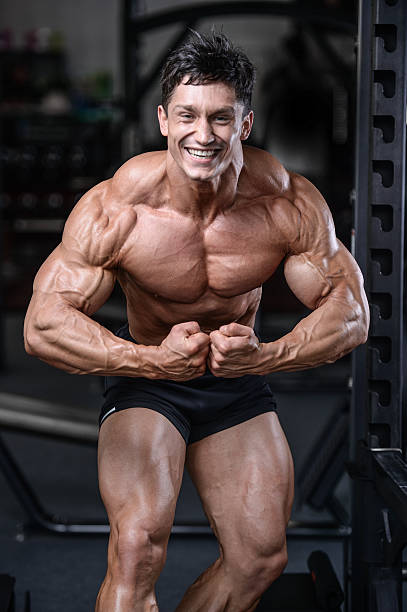 istock Handsome bodybuilder training in the gym sexy man lift dumbbells 637715976