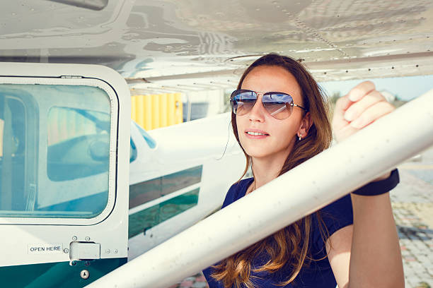 istock Young smiling woman standing near private plane 637716174