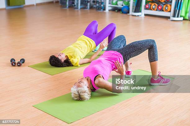 Women Training Their Glutes By Doing Bridging Exercise On Mats Stock Photo - Download Image Now