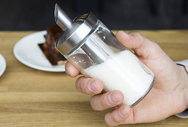 istock Man's hand holding a sugar dispenser 637717956
