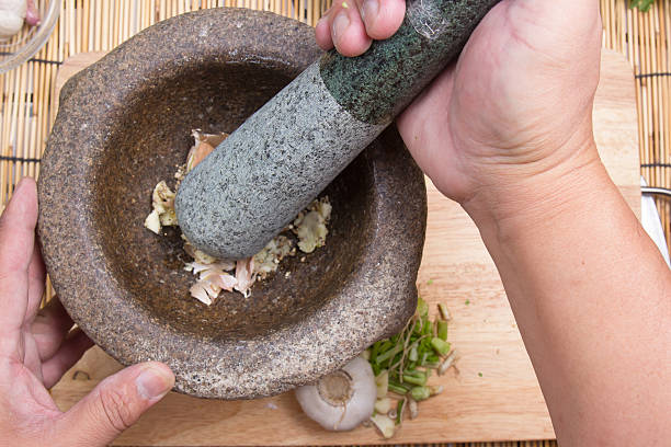 istock Chef pound pepper and garlic with pestle on mortar 637722576