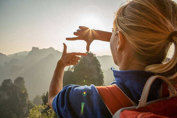 istock Young woman framing mountain landscape with hands 637723140
