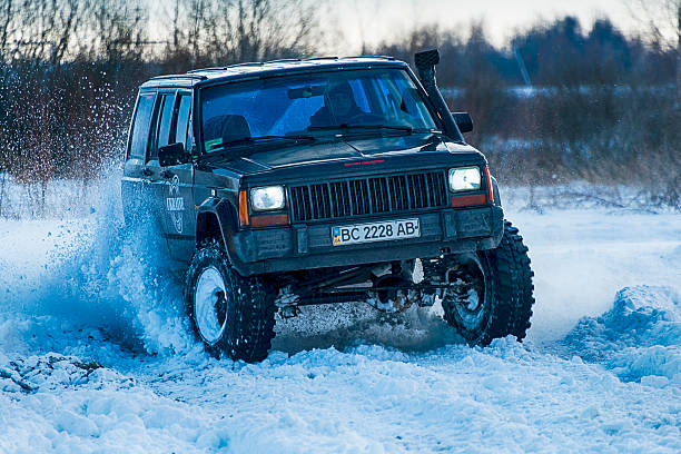 off-road vehicle brand jeep cherokee supera la pista - off road vehicle snow 4x4 driving fotografías e imágenes de stock