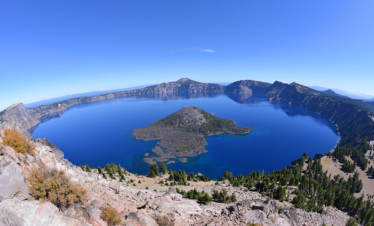 Wide angle view of a lake, deep blue water filling collapsed, volcanic caldera, Oregon, USA.