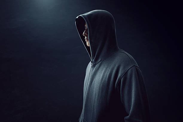 Man standing alone in dark room stock photo