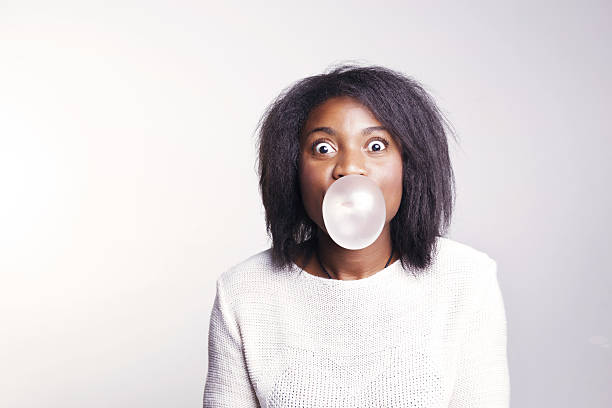 istock African woman making bubbles with a chewing gum. 637729580