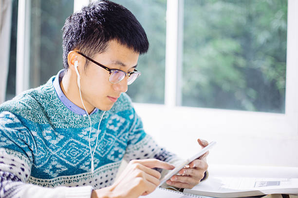 istock young asian man studying by tablet in classroom 637729588