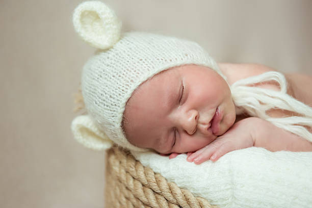 istock Newborn baby sleeps in a basket. Hat with ears 637729600