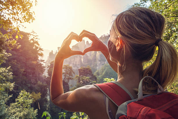 Young woman loving nature Young woman hiking in the Zhangjiajie National Forest park, makes a heart shape finger frame. Love nature wanderlust sharing concept. zhangjiajie photos stock pictures, royalty-free photos & images