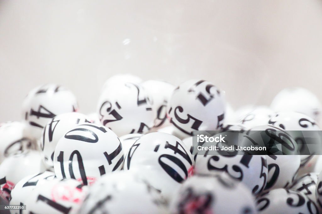 Group of black and white lottery balls Many white lottery balls with black numbers on them are close together. Close up shot is taken against a white background. Taken by Canon 5D Mark lv. Lottery Stock Photo