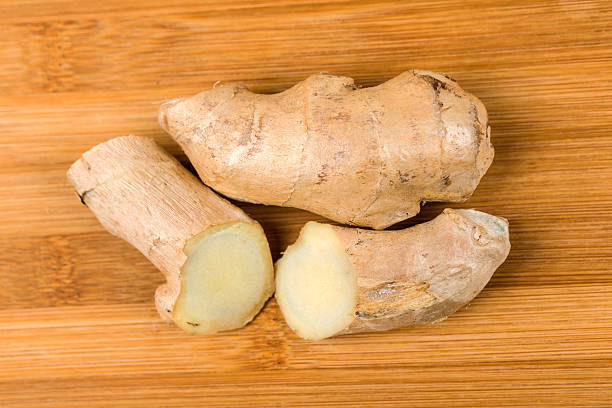 istock Sliced ginger root isolated on a wood background 637734584