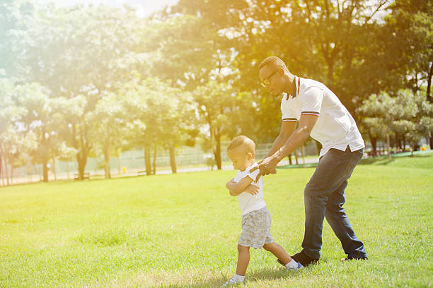 istock Father and son running and chasing each other in park 637735358