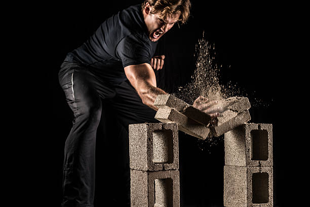 male fighter breaking bricks - broken stones stock-fotos und bilder