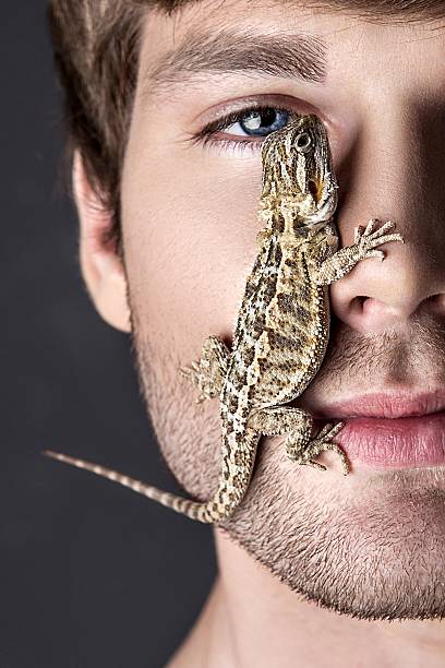 istock Portrait of a Young Handsome Man with Lizard 637738354